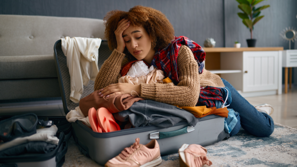 Woman having a miserable time unpacking from vacation.