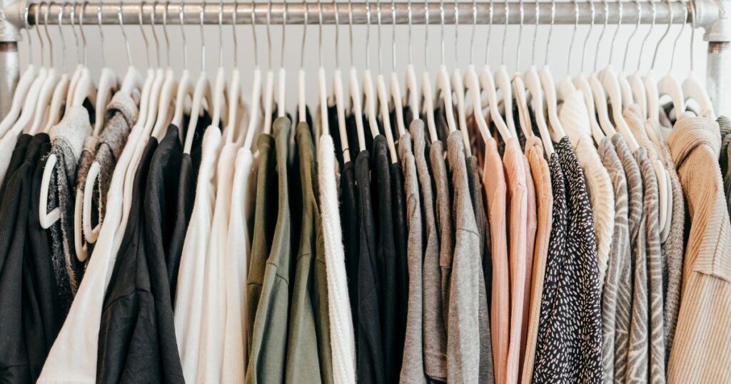 An organized wardrobe with colorful clothing on white hangers, highlighting style, cleaning, and organization.