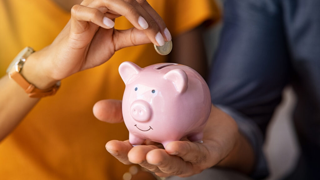 Couple saving coins in biggy bank for laundry
