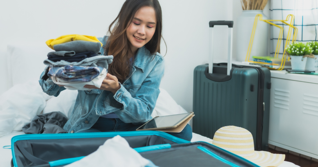 Traveler organizing clothes and laundry bag using travel laundry hacks to keep clothes fresh on the move.