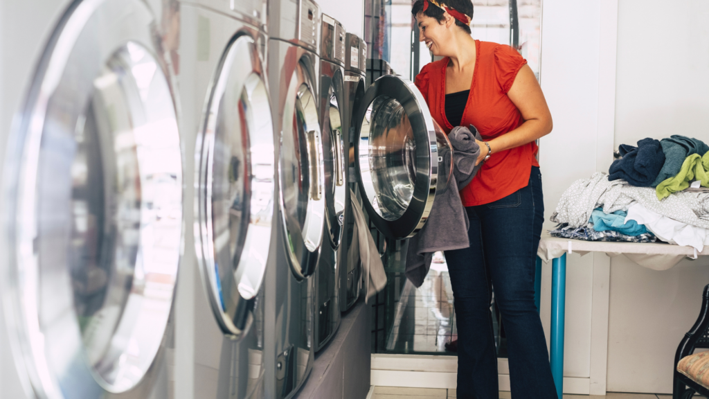 A woman utilizing the strong machines at Anthony’s Laundromat in Sacramento to save energy when doing laundry. 